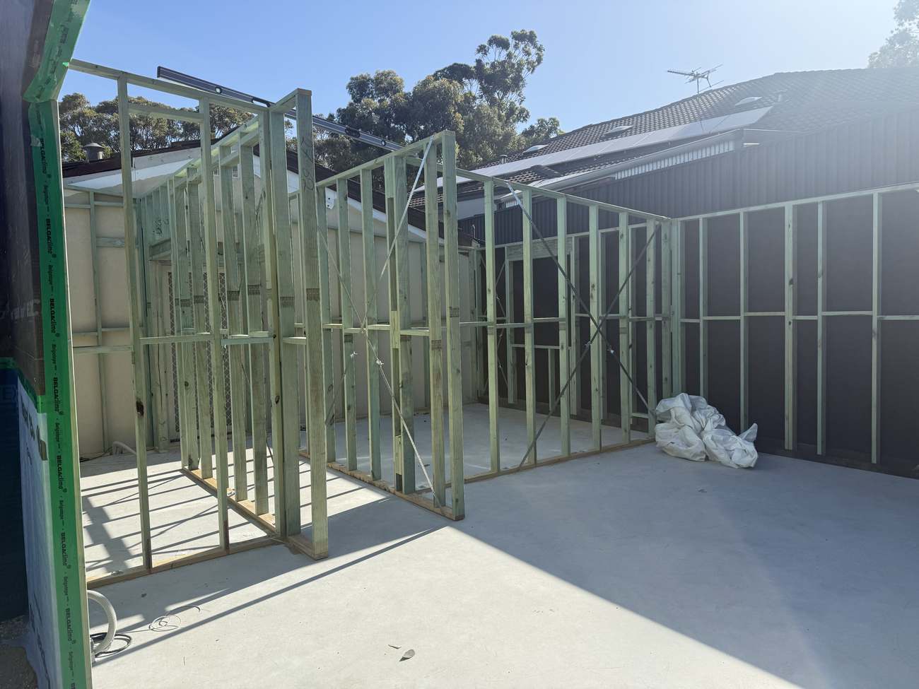New addition wrapped in wall-protection membrane with the skillion roof on, taped at every lap.